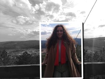 Portrait of young woman standing on mountain against sky