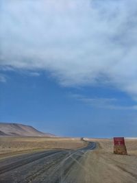 Road leading towards desert against sky