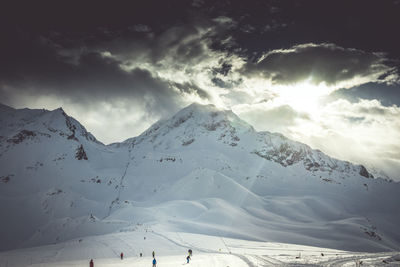 The sunshine breaking through the clouds above the ski slopes in les arcs