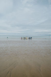 People on beach against sky