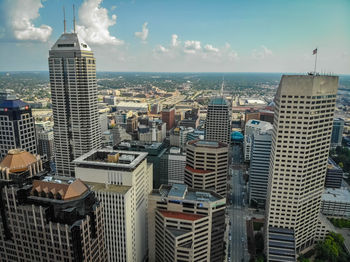 Aerial view of buildings in city against sky