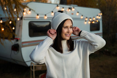 Smiling young woman wearing knit cap looking away