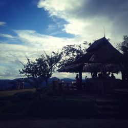 Houses by trees and buildings against sky