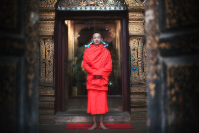 Woman standing by red outside building