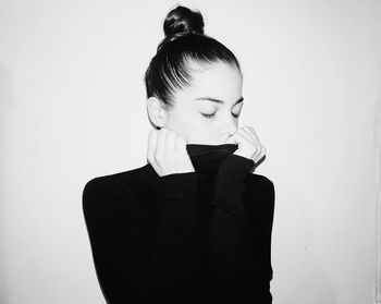 Young woman standing against white background