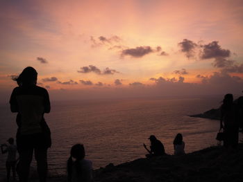 Silhouette people on beach during sunset