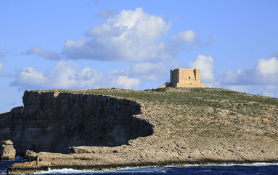 Rock formations on building against sky