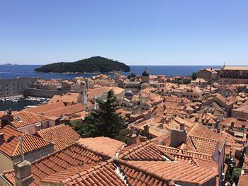 High angle view of townscape by sea against clear sky