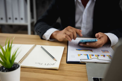 Midsection of man using laptop on table