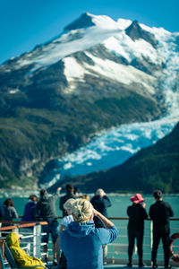 People looking at snowcapped mountains