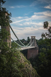 Bridge over buildings against cloudy sky