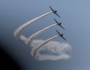 Low angle view of airshow against clear sky