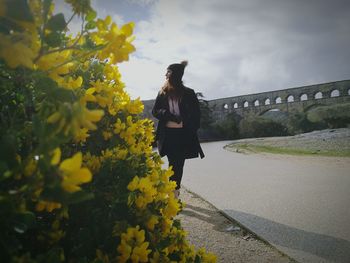 Full length of woman standing on yellow bridge against sky