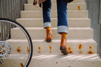 Cool hipster man walking up the stairs. low section close-up of shoes.steps forward into a success