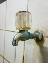 Close-up of water faucet against wall at home