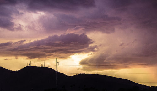 Silhouette mountain against dramatic sky during sunset