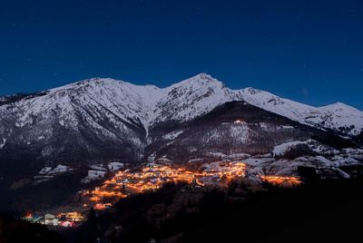 Aerial view of snowcapped mountains against clear blue sky