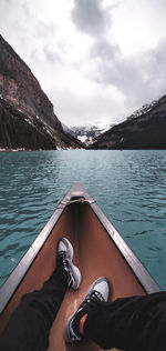 Low section of person in lake against sky