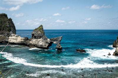 Scenic view of rocks in sea against sky