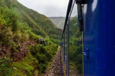 Train by green mountains