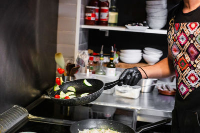 Midsection of woman preparing food in kitchen