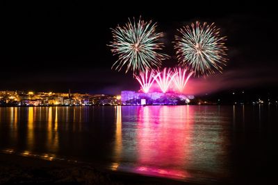 Firework display over river at night