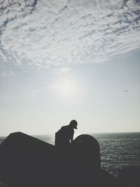 Silhouette horse on rock against sky during sunset