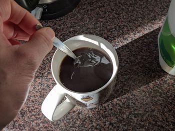 High angle view of hand holding coffee cup