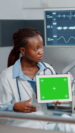 Doctor showing digital tablet at clinic