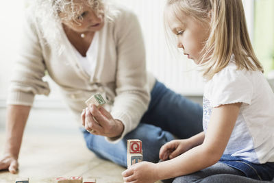 Female teacher showing block to girl in day care center