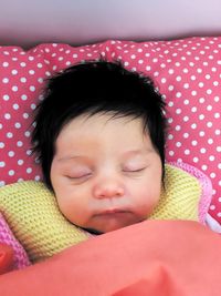 High angle view of cute baby girl sleeping on bed