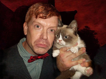 Close-up portrait of man with cat