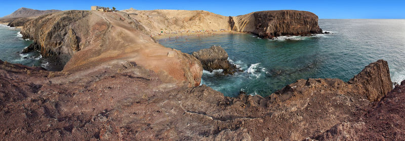 Scenic view of rocks in sea against sky