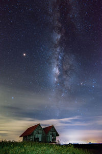 House on field against sky at night