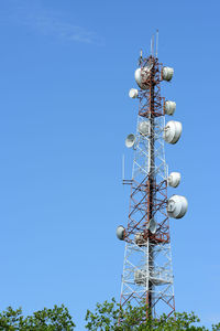 Low angle view of communications tower against blue sky