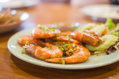 Close-up of cooked prawns served in plates on table