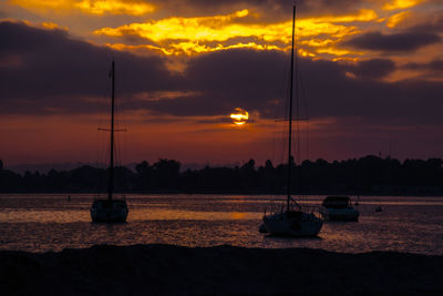 Sailboats on sea against sky during sunset