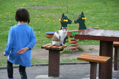 Rear view of boy playing with dog