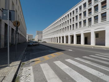 Road by building against sky in city