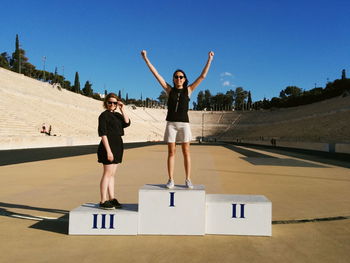 Portrait of smiling friends on winners podium at panathinaiko stadium