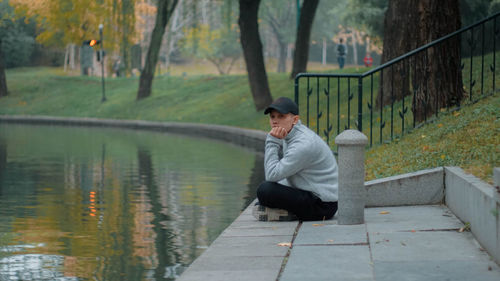 Side view of woman sitting on pier