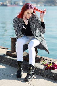 Full length of woman sitting outdoors