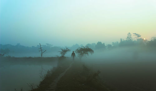 Scenic view of lake against sky during foggy weather