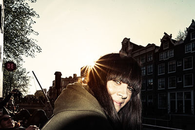 Woman looking at camera against sky