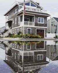 Reflection of building in city against sky