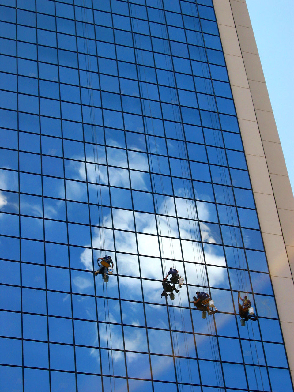 LOW ANGLE VIEW OF MODERN GLASS BUILDING