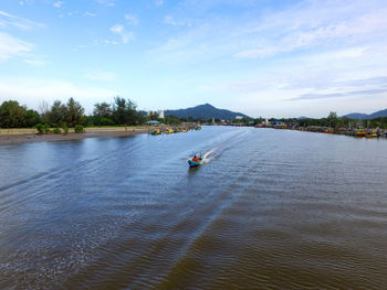Man sailing on river against sky