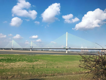 View of suspension bridge against cloudy sky