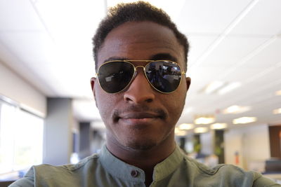 Portrait of young man wearing sunglasses at office