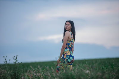 Woman standing on field against sky